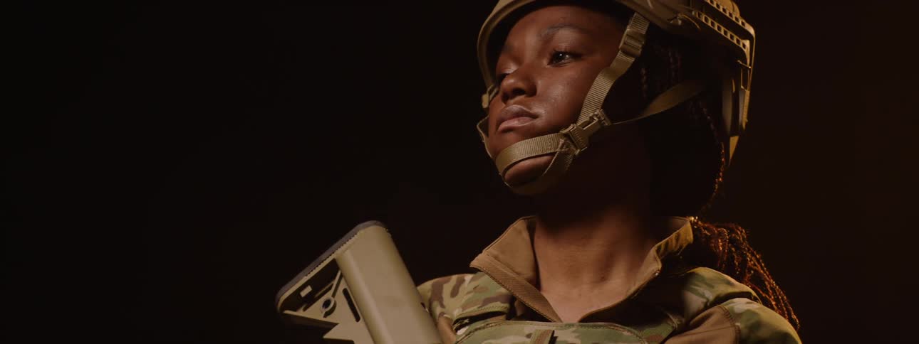 The soldier holds her rifle as the lights go out on her