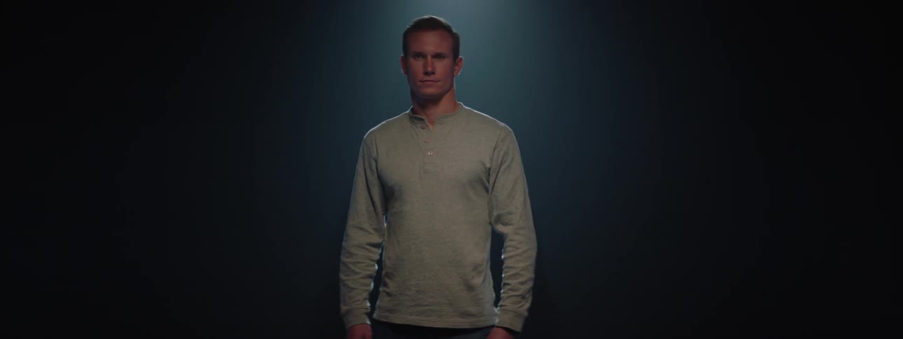Man in gray long sleeve shirt in an indoor space
