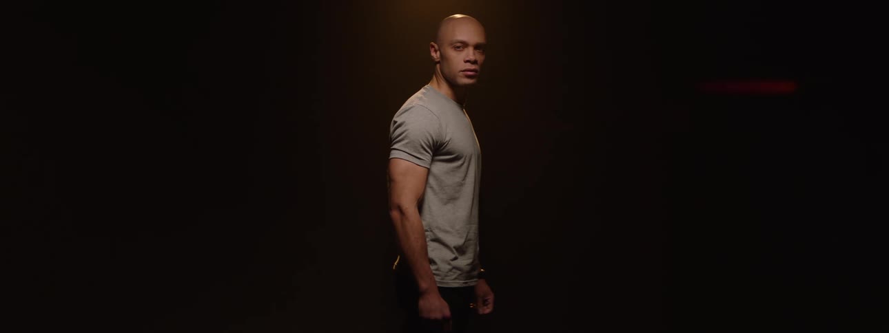 Bald man in a gray tshirt in a studiolit space