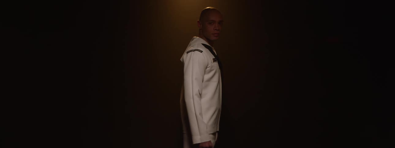 A sailor is slowly turning in the dark room