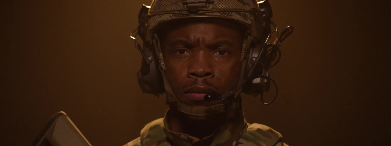 The soldier is wear a camouflage uniform and holding a rifle
