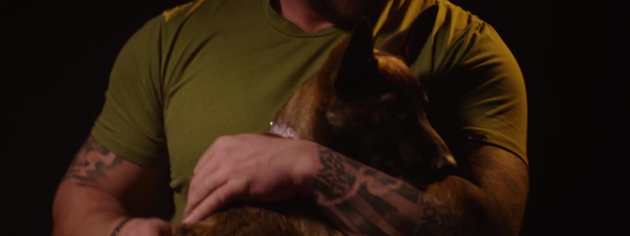 A man is hugging and petting his dog
