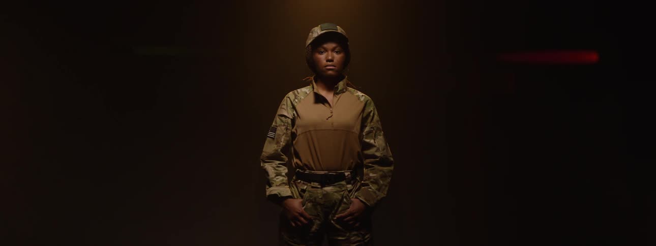 The soldier is standing on the dark stage