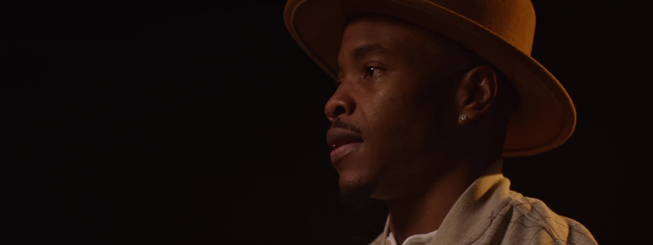 The man is wearing a short brimmed hat