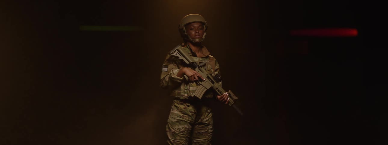 Woman in helmet and military uniform holding a weapon