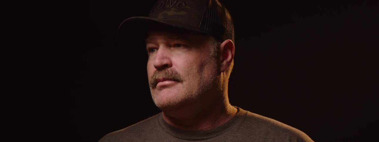Man wearing a cap in an indoor space with studio lighting