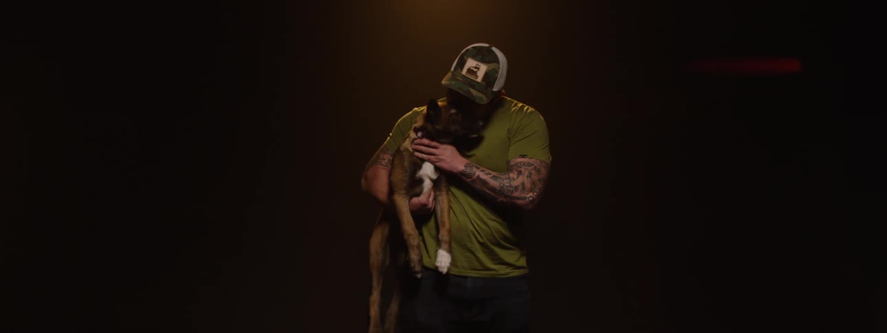 The man is holding his dog