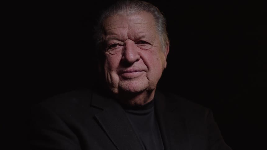 The man is smiling in the dark room