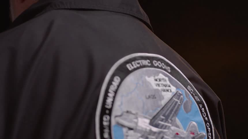 A man is wearing a jacket with artwork on it