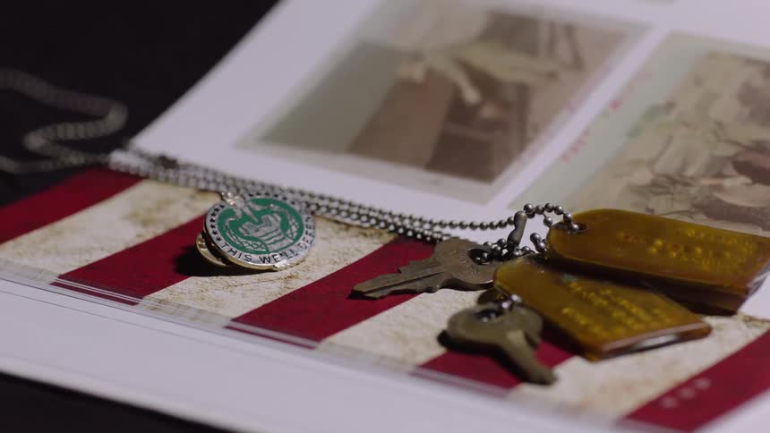 Key and pendant next to a book with old photos