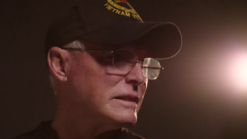 A man is wearing a military cap