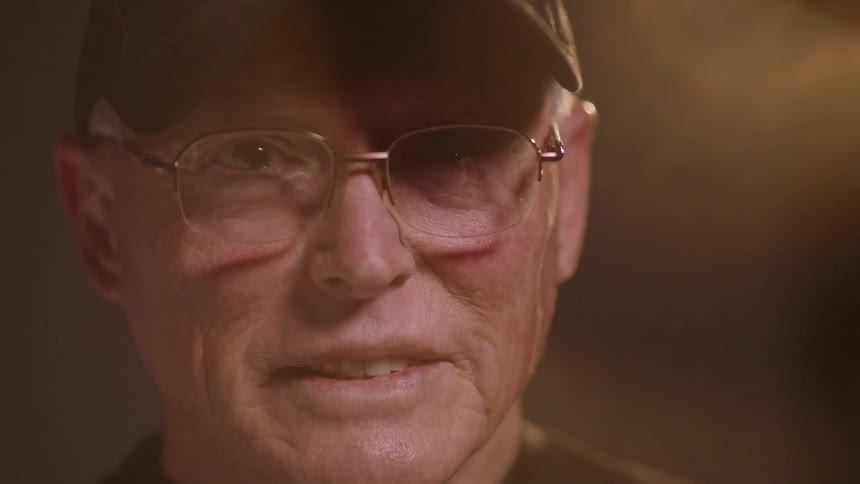 An old man wearing a vietnam veteran hat
