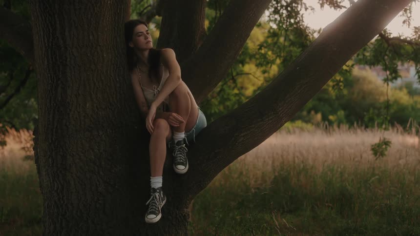 Woman sitting and relaxing in a tree