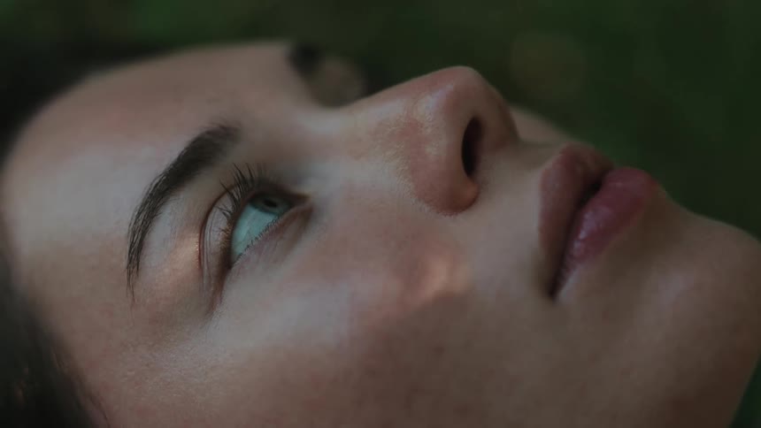 Side portrait of a young woman lying down outdoors