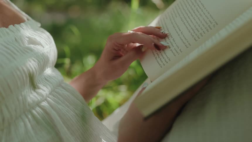 Pair of womans hands interacting with a book