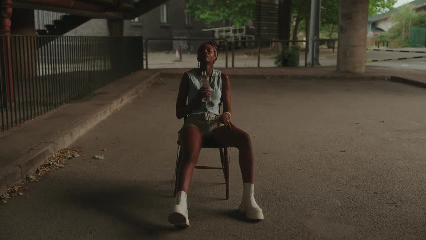 Young woman on a chair with a glass bottle