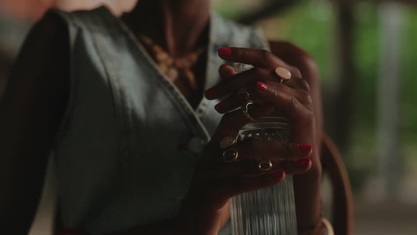 Womans hands holding a glass bottle of water