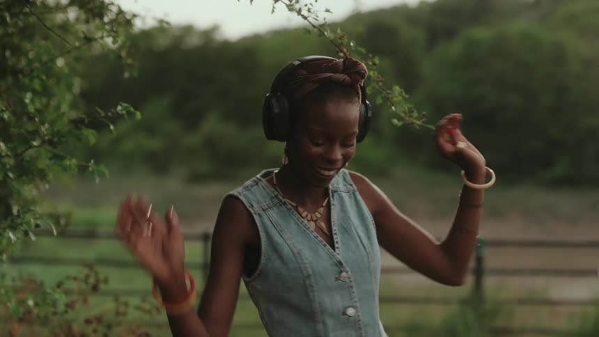 Woman outdoors enjoying music with headphones
