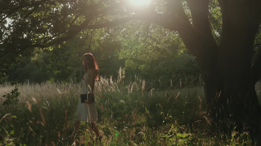Woman in white dress walking through a field