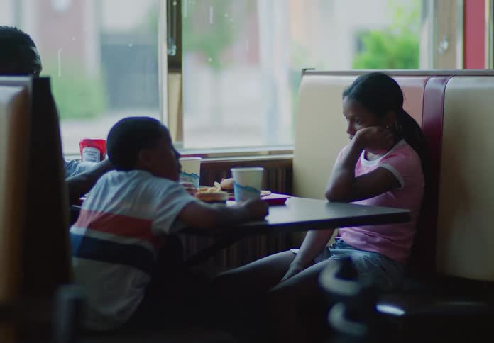 A family sits together at a diner booth sharing a meal