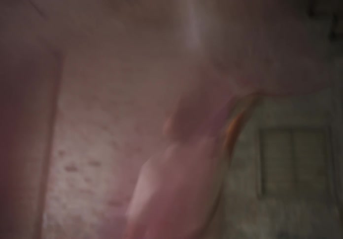 Woman spins with flowing pink fabric in a soft blurred motion indoors