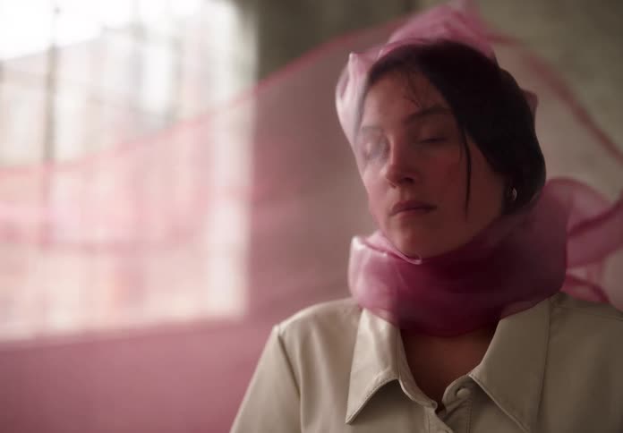 Woman with a pink scarf on her face