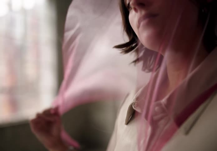 Woman in an indoor space with a pink scarf on her head