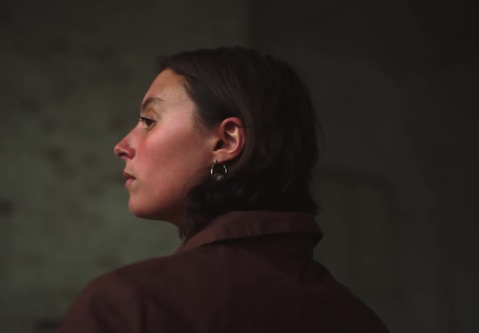 Side portrait of a young woman in a brown coat