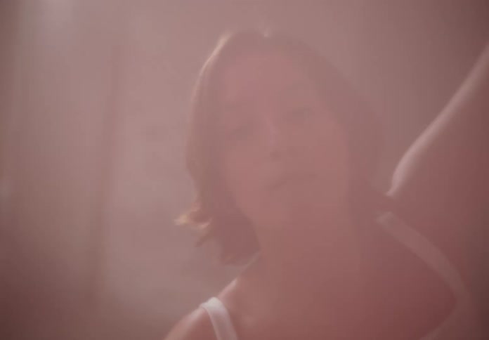 A young woman dancing ballet in a dimly lit room