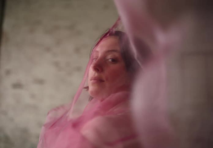 Woman holding a pink translucent fabric