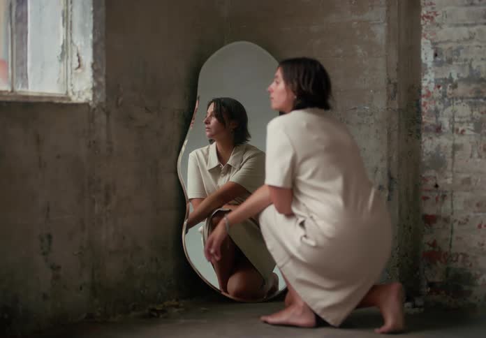 Woman parading and squatting in front of a mirror