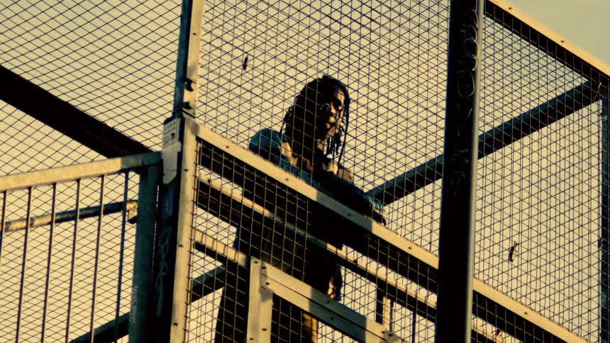 The woman looks down from the overpass