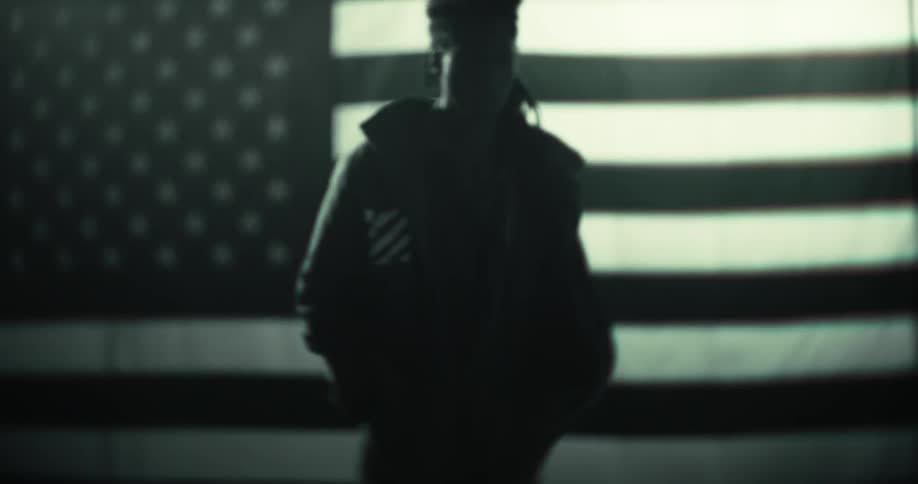 Dread man with a coat walking and in the background the american flag