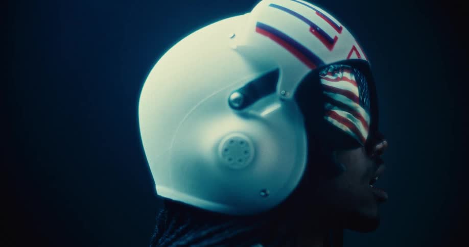 An american flag waves in the reflection of the visor on a mans helmet