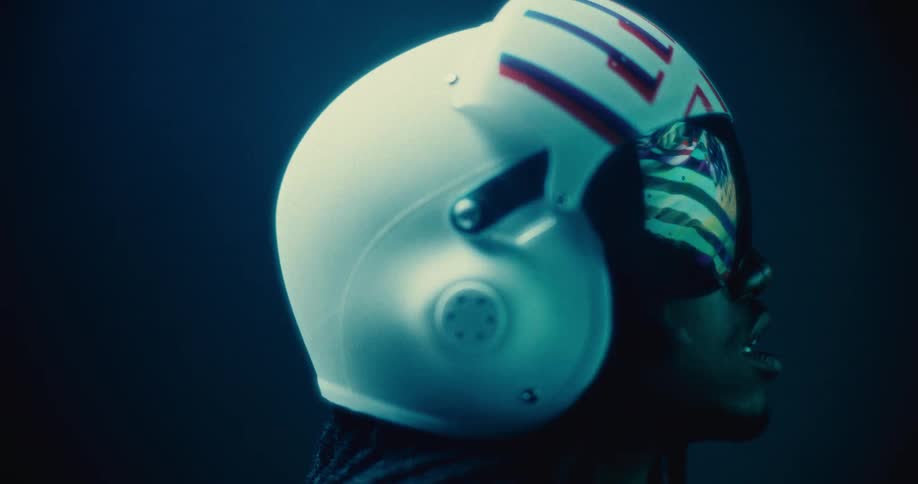 A man wearing a helmet watching a screen at night