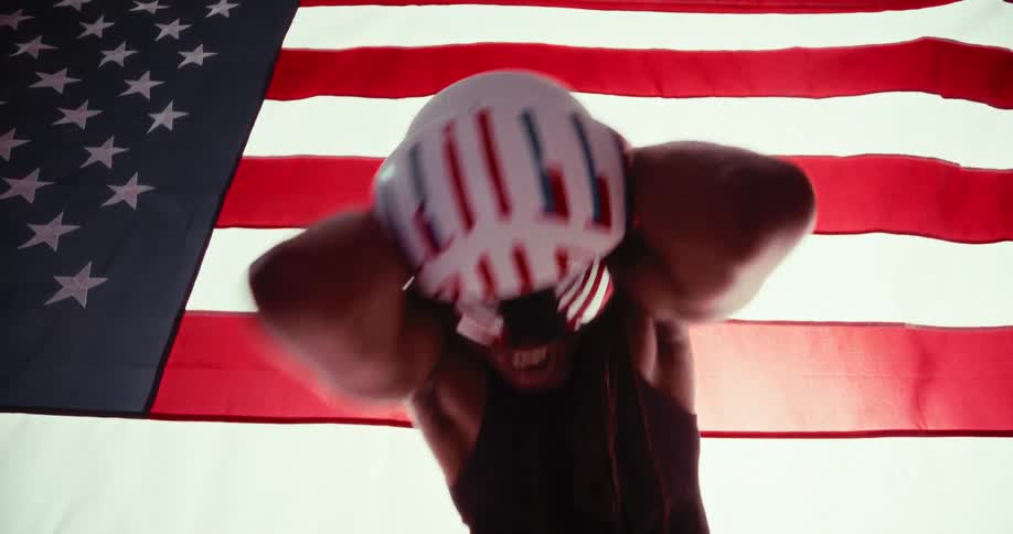 Man in helmet making vibrant movements with the american flag in the background