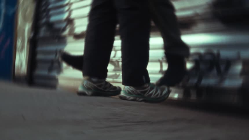 Legs of two people one of them suspended and swinging next to a metal door