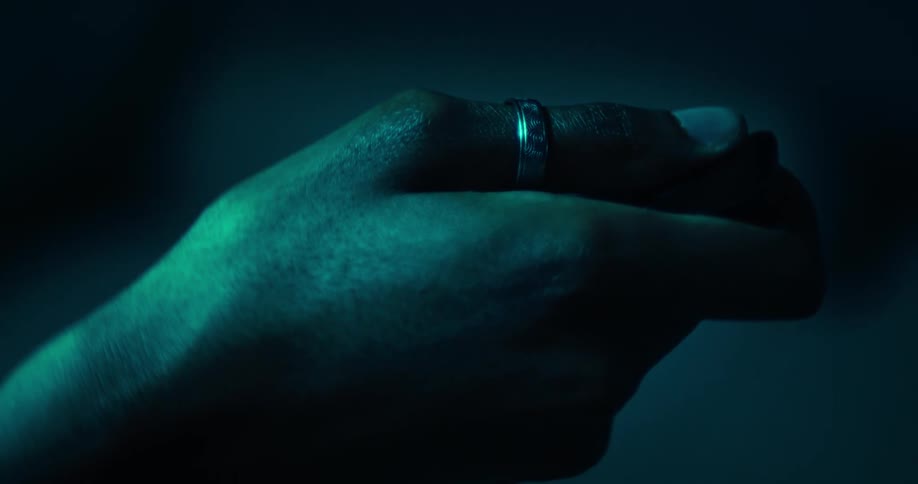 Hand with a ring holding a device