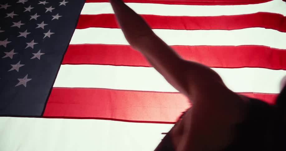 The man is dancing in front of an american flag