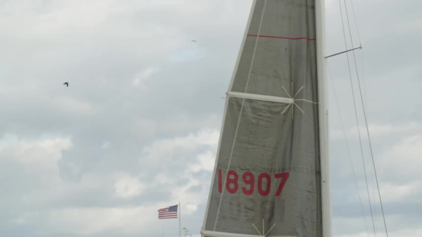 Closeup shot of a gray sailboats main sail made of a technical fabric