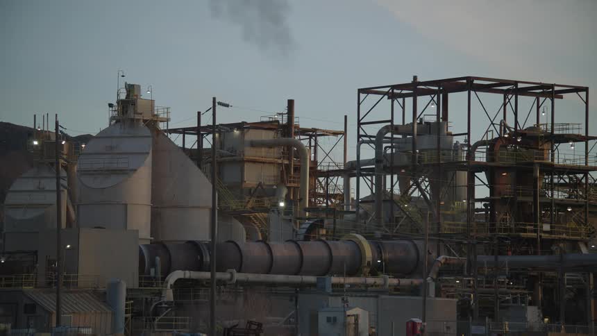 Worker moves along the outside of a building in a manufacturing plant