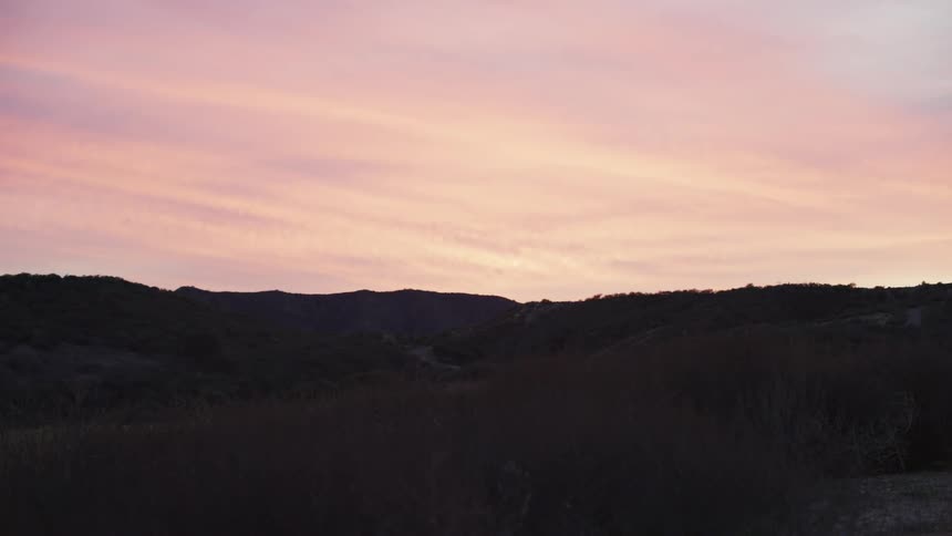 Silhouette of mountains against a reddish sky