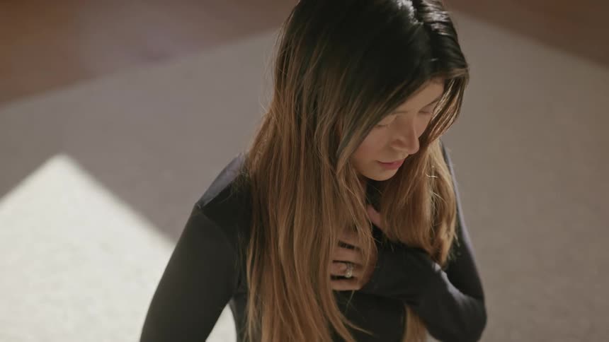 Woman with eyes closed and hand on chest