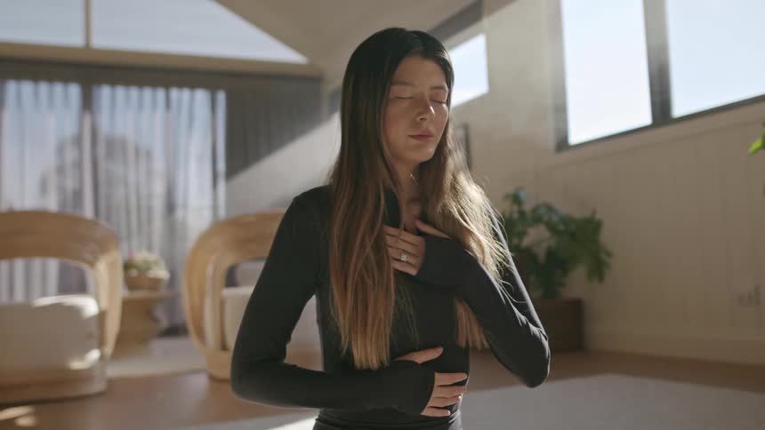 Woman in an indoor setting possibly a living room or a dedicated space for mindfulness or yoga