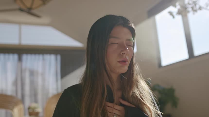 The woman is sitting and meditating at home