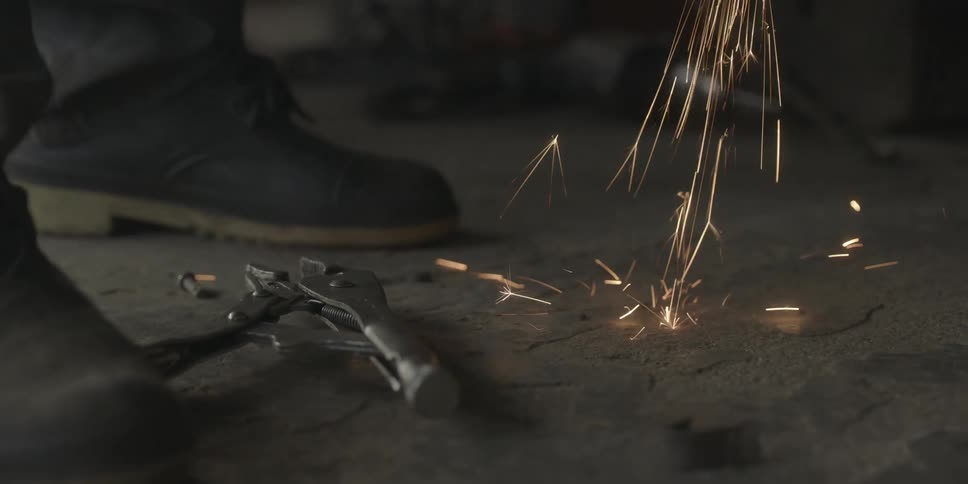 Sparks hit the ground while the angle grinder is in use