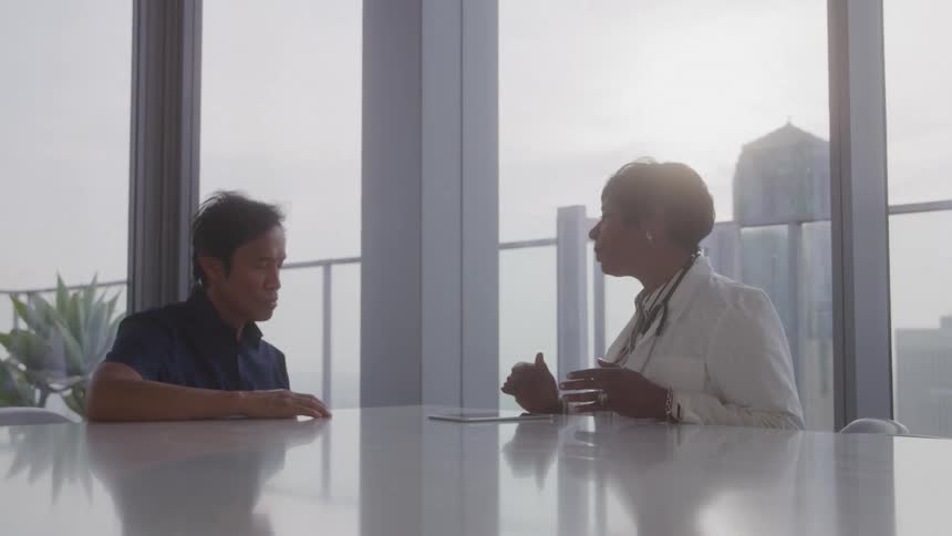 A man is listening to a doctor in the hospital
