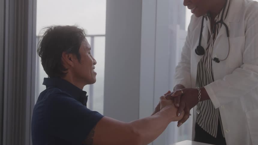 A doctor shakes hands with a patient