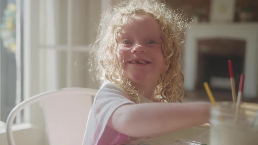 Closeup shot of a young child with a joyful smile looking directly at the camera