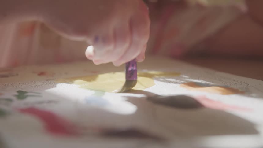 The child is painting with water colors